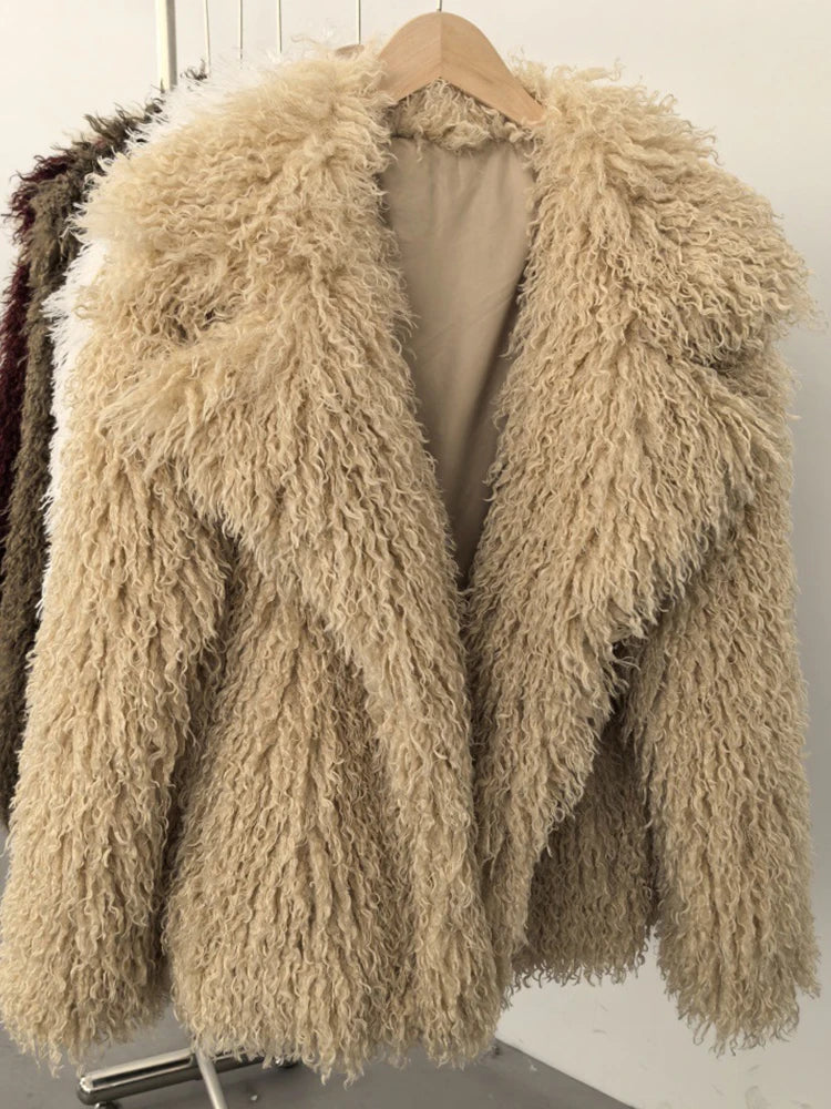 Beige fluffy jacket on a hanger against a white wall