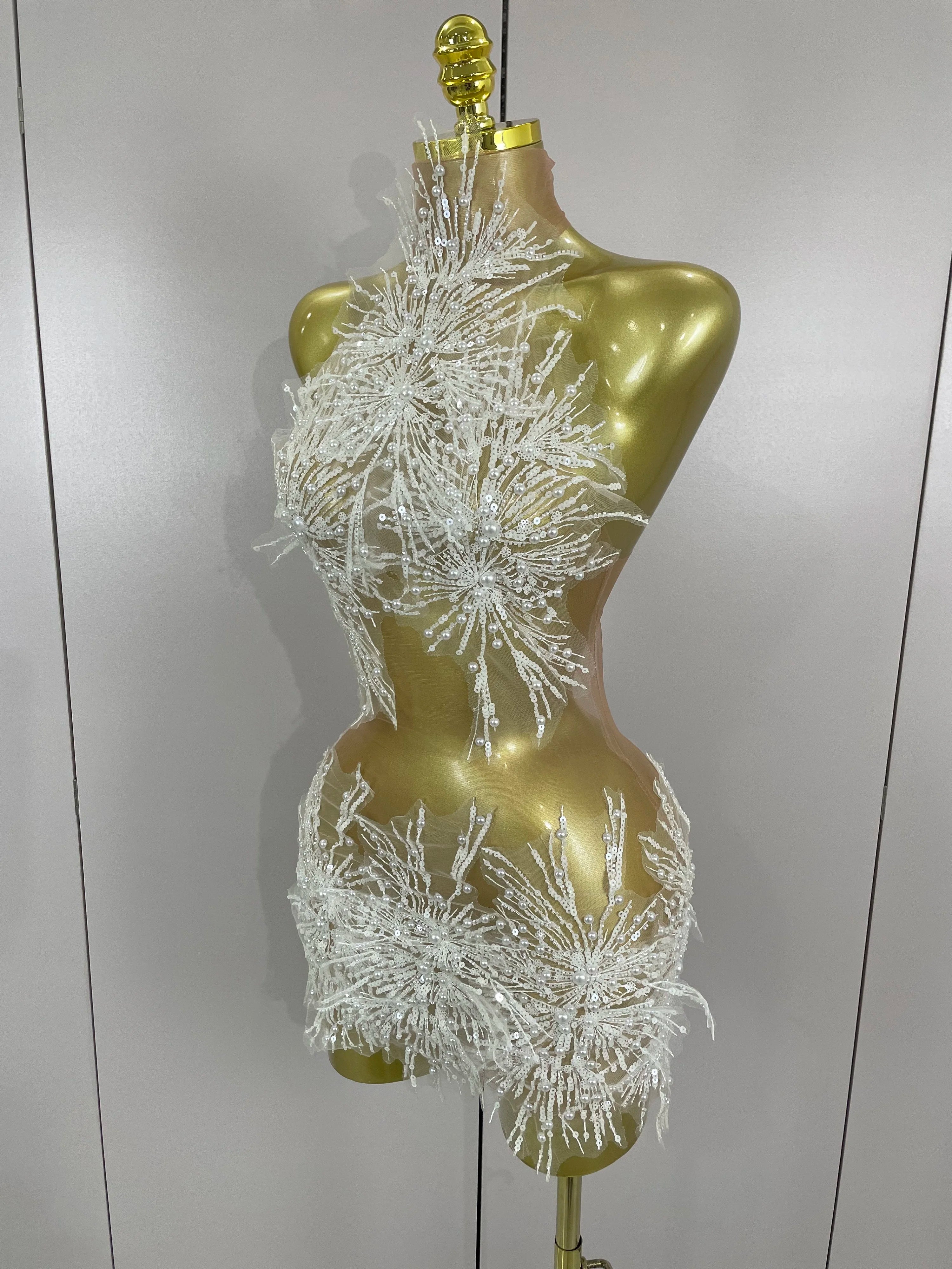 Mannequin wearing a silver beaded dress against a plain background