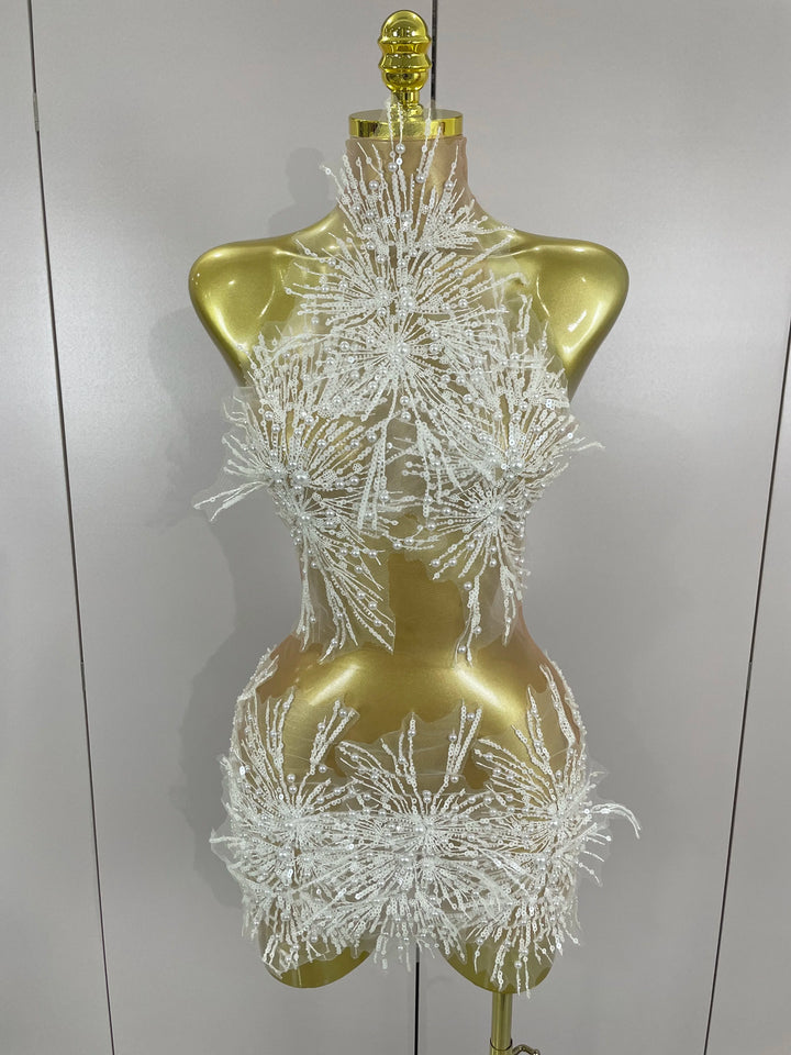 Mannequin wearing a sparkling white dress against a plain background